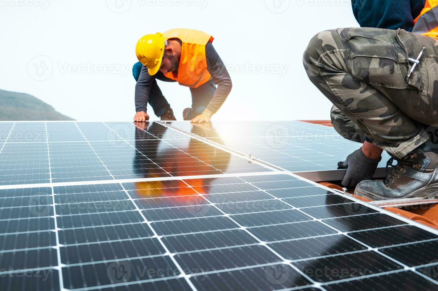 trabajadores montar energía sistema con solar panel para electricidad y caliente agua foto