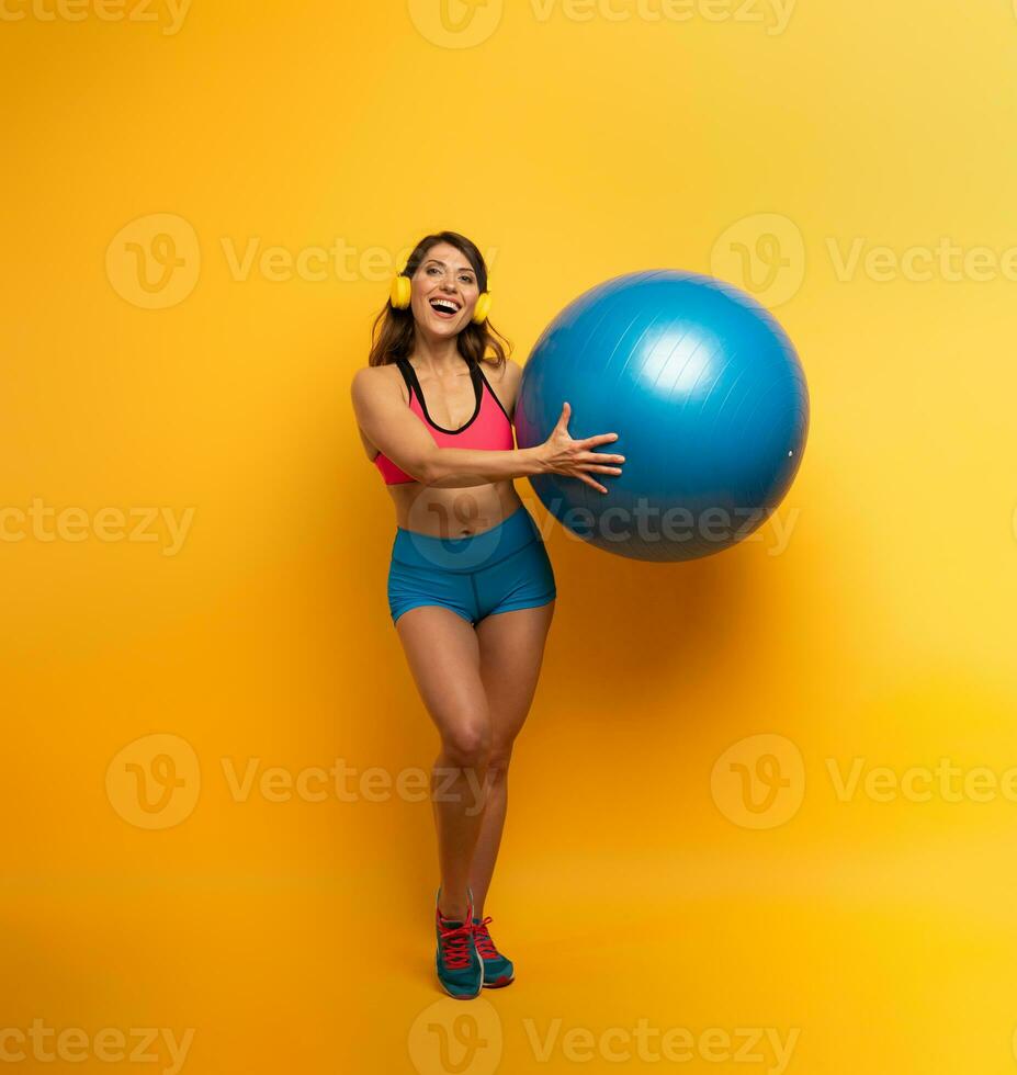 niña con gimnasio pelota y auriculares es Listo a comienzo aptitud actividad foto