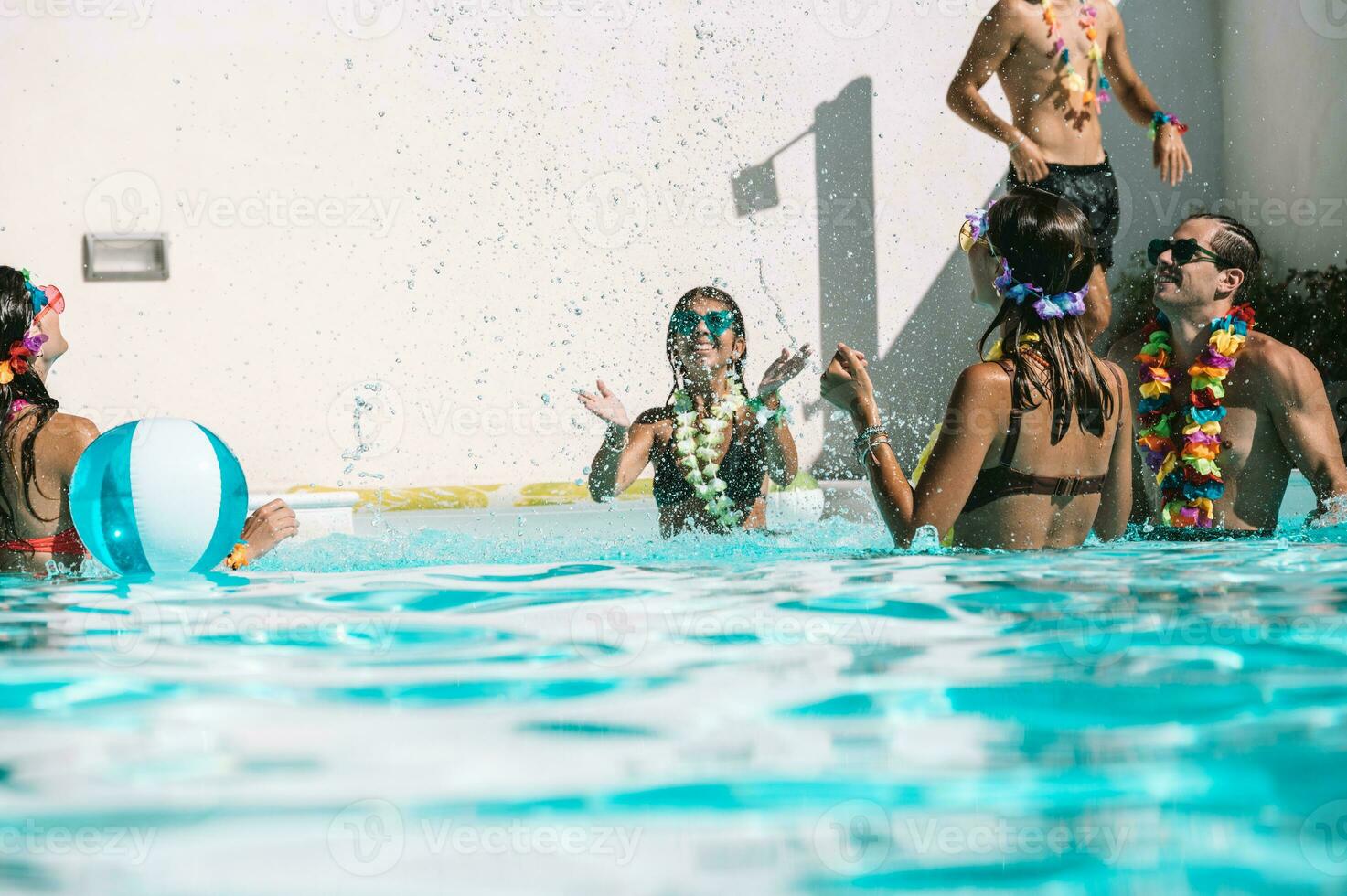 Group of friend play together in the swimming pool photo