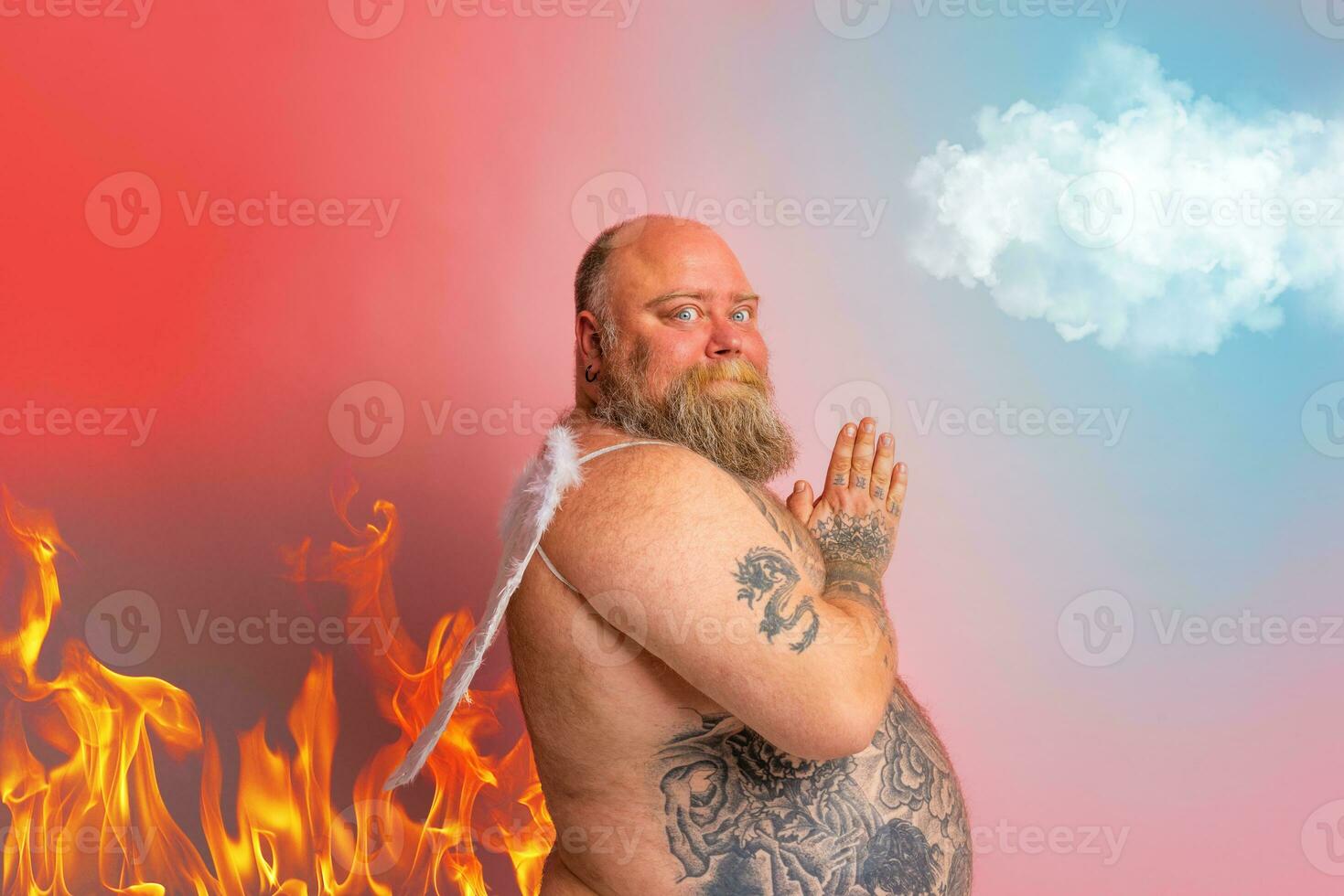 Fat man with beard, tattoos and wings acts like an angel photo