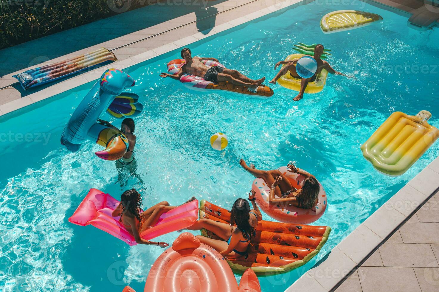 amigos en traje de baño en el piscina consiguiendo un bronceado foto