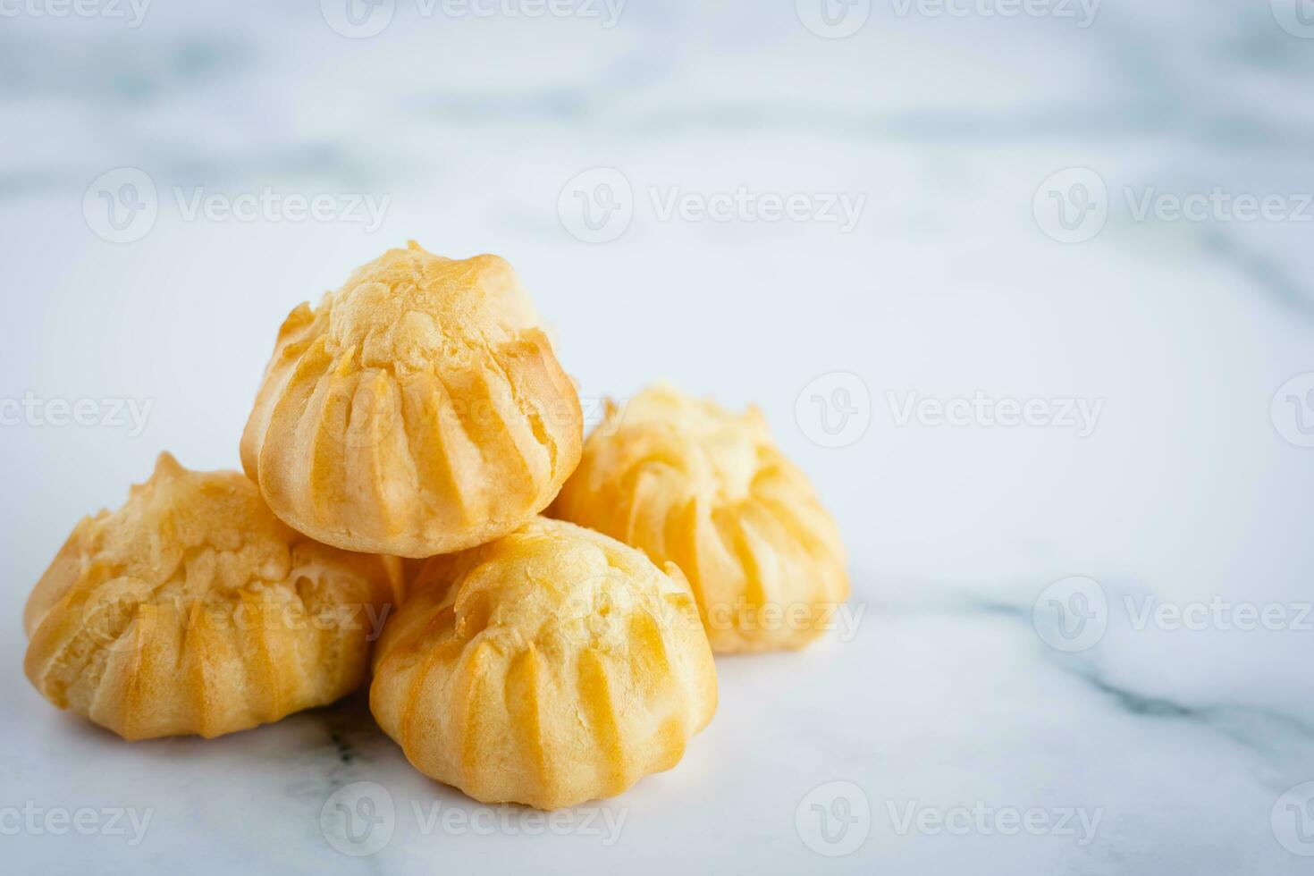 Delicious eclair vanilla cream, choux dough filled with a cream, homemade bakery on white marble background photo