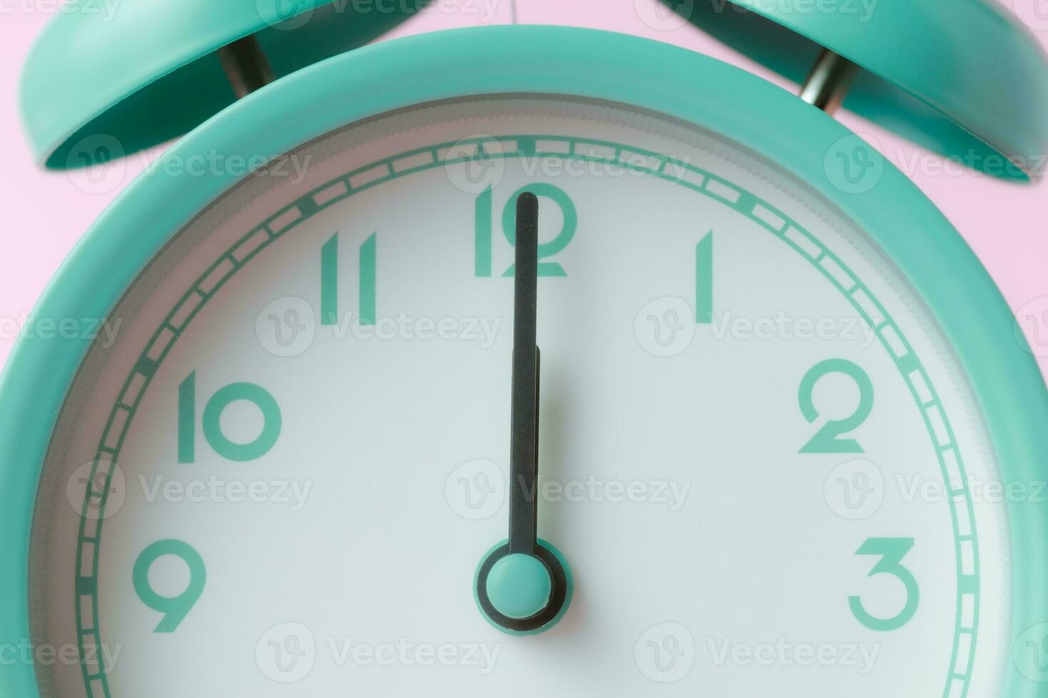 An enlarged image of a bell alarm clock with the hands pointing to noon photo
