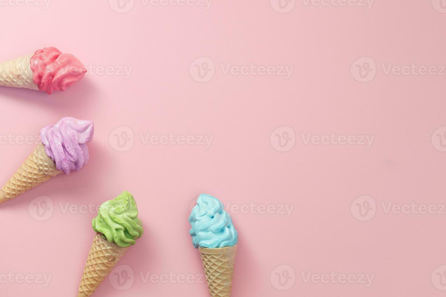 Various of colourful meringue ice cream cone on pink background photo