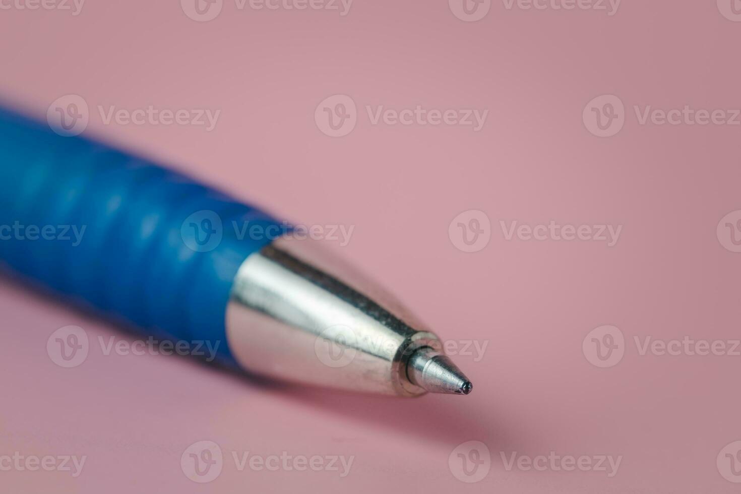 Closeup image of the pointed end part of a pen on pink background photo