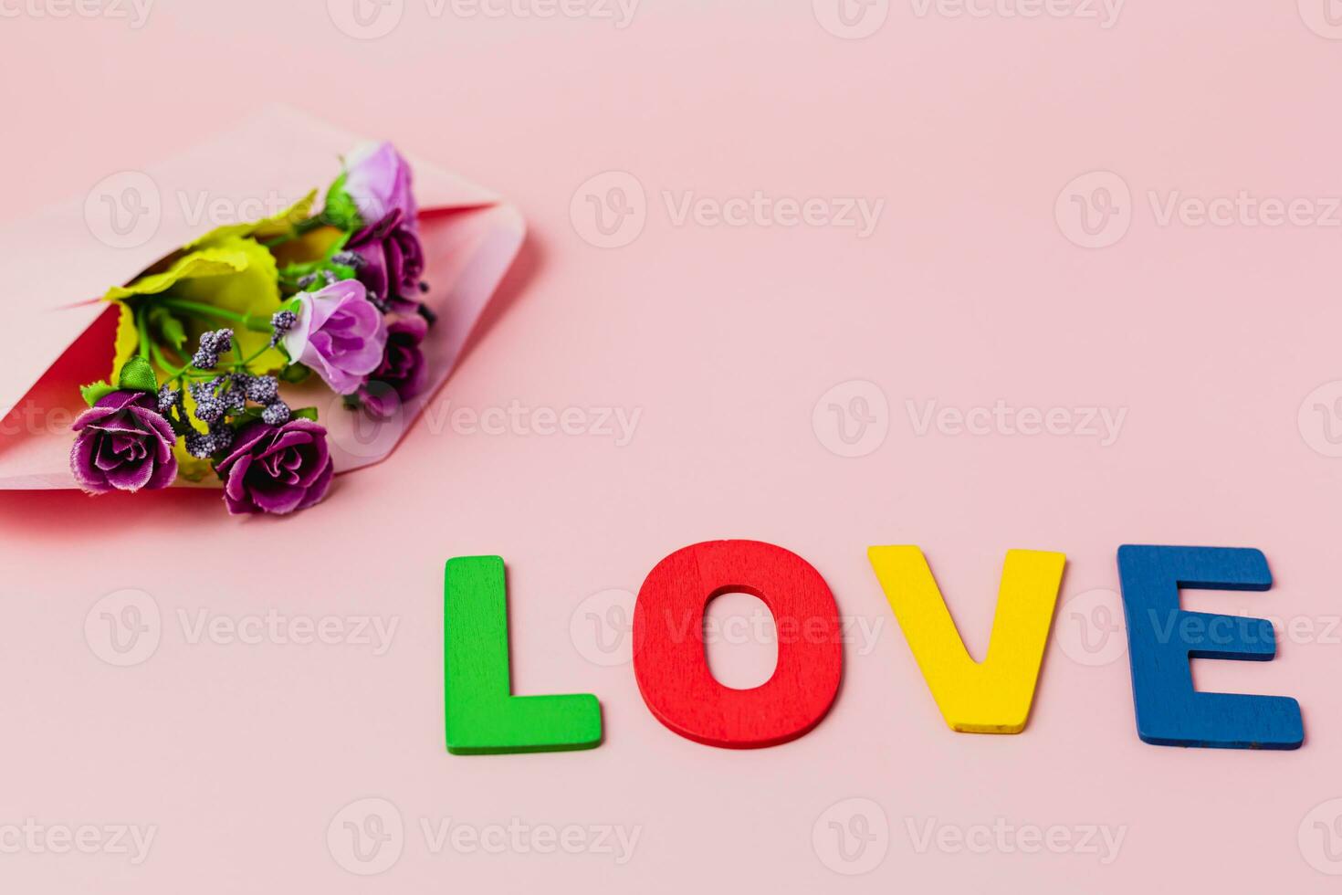 LOVE word with artificial purple rose bouquet in envelope photo