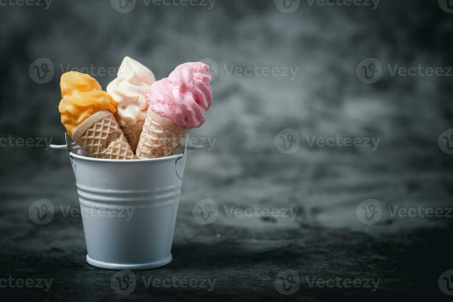 Various of colourful meringue ice cream cone in the bucket photo