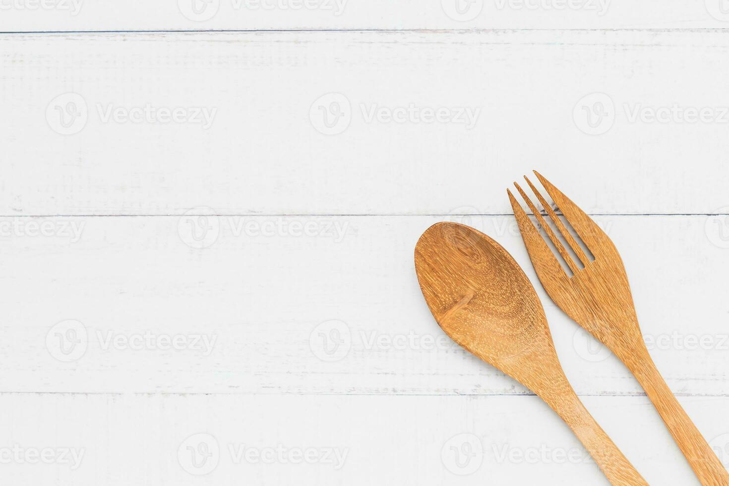 Wooden spoon and fork on white table background for utensil and kitchenware concept photo