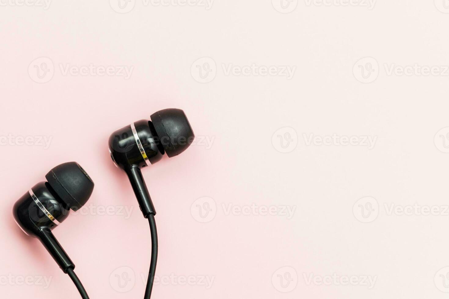 Black earphones on pink background photo