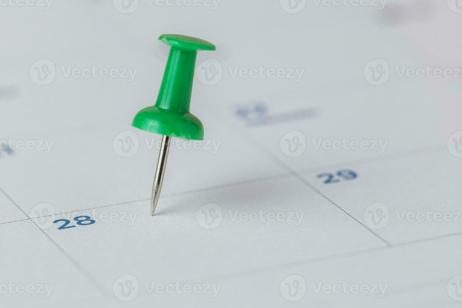 A green push pin marking on calendar photo