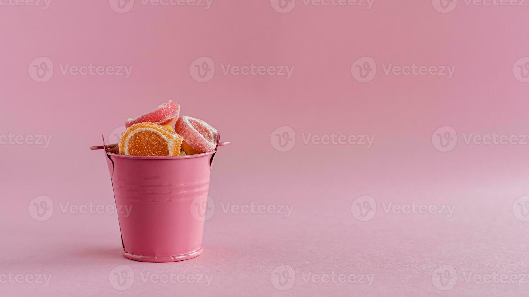 lleno de vistoso Fruta jalea caramelo en un rosado Cubeta foto