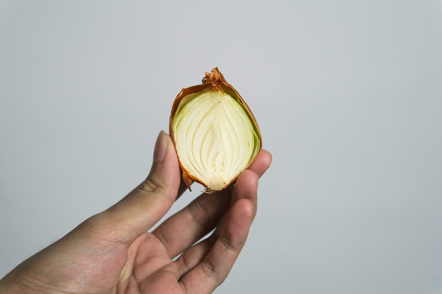 mano participación rebanado ajo aislado en blanco antecedentes. el concepto de el utilizar de ajo y sano comiendo foto