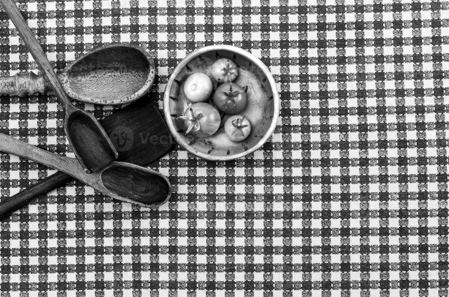 Rustic wooden spoons amd tomatoes on the table. photo