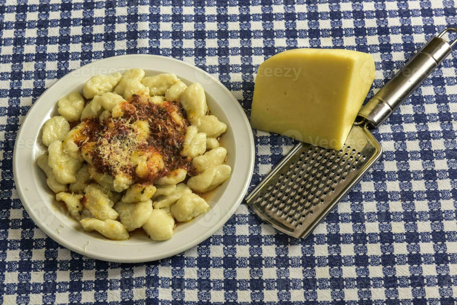 plato de hecho en casa Ñoquis con rallado queso en el mesa foto