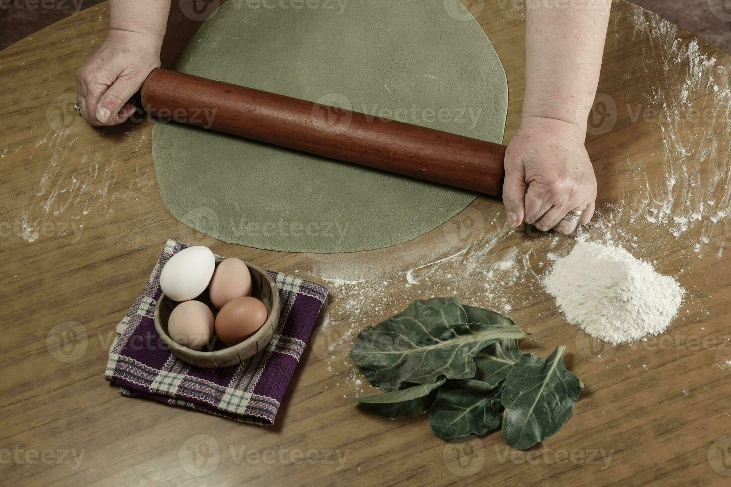 de la abuela manos amasadura, masa para verde fideos. foto