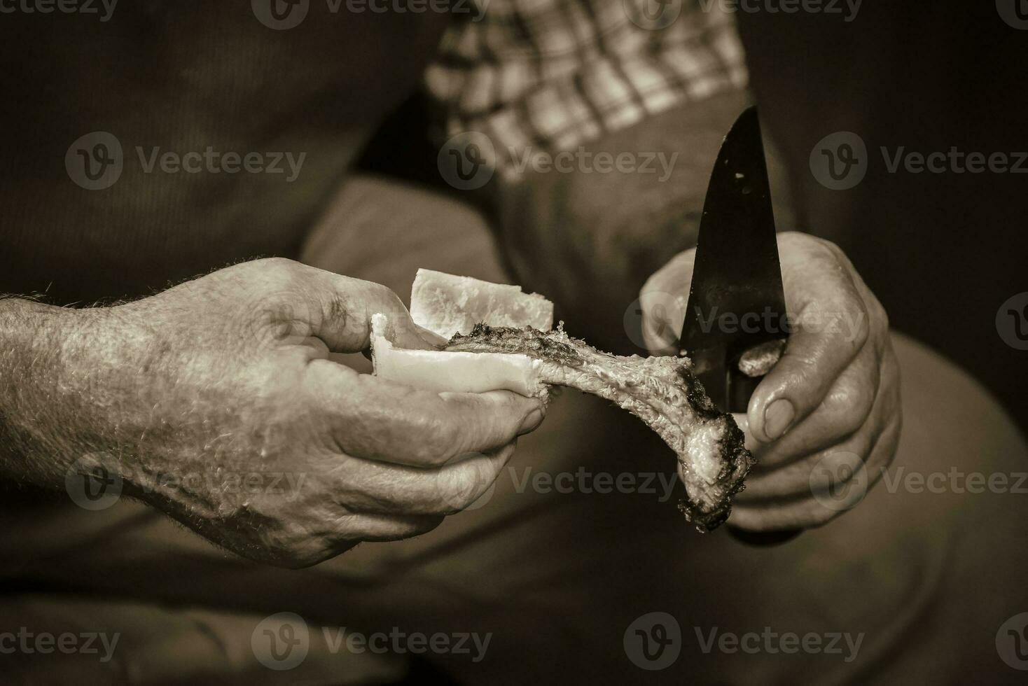 Gaucho cutting a roasted rib, Patagonia Argentina photo