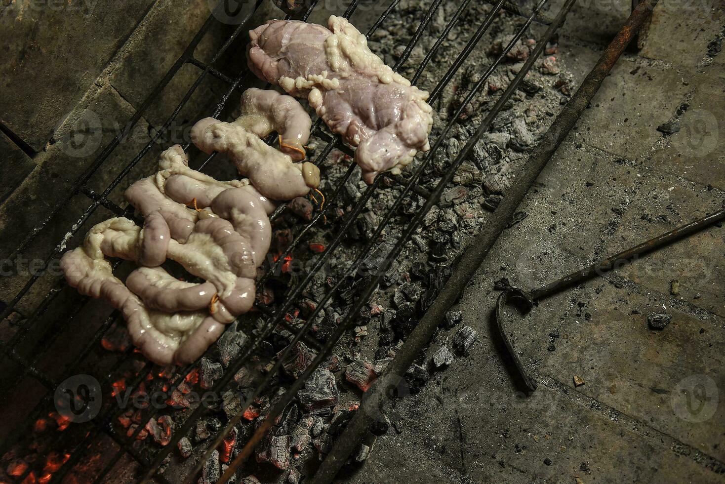 Cow bowels presented on a wooden board with ingredients, ready to grill photo