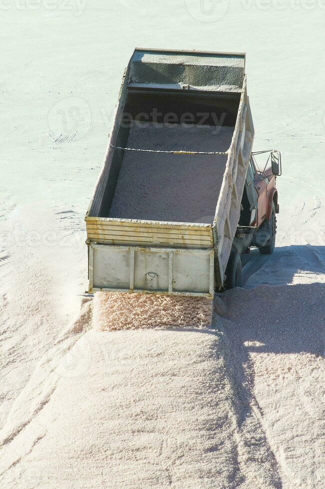 Trucks unloading raw salt bulk, Salinas Grandes de Hidalgo, La Pampa, Argentina. photo