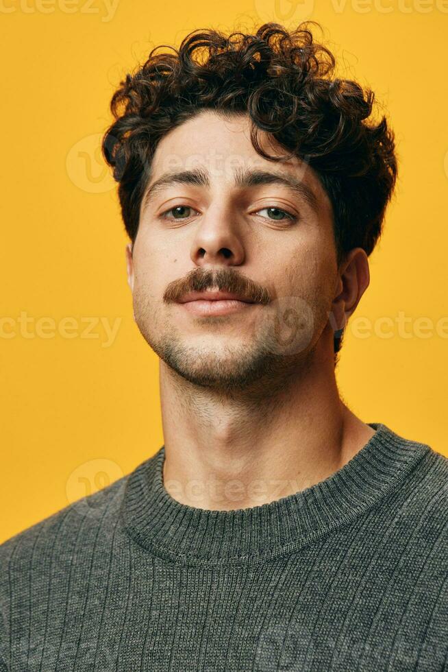 Young man hair student happy smile portrait sweater orange trendy background hispanic fashion photo