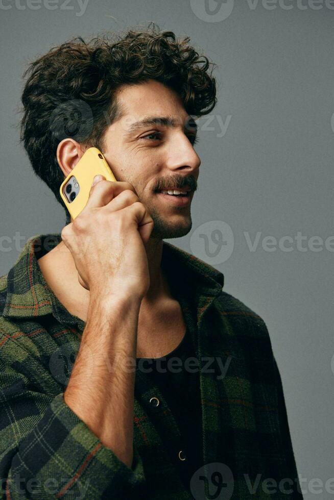 One man smile shirt stylish happy phone studio background attractive technology fashion listen grey lifestyle photo