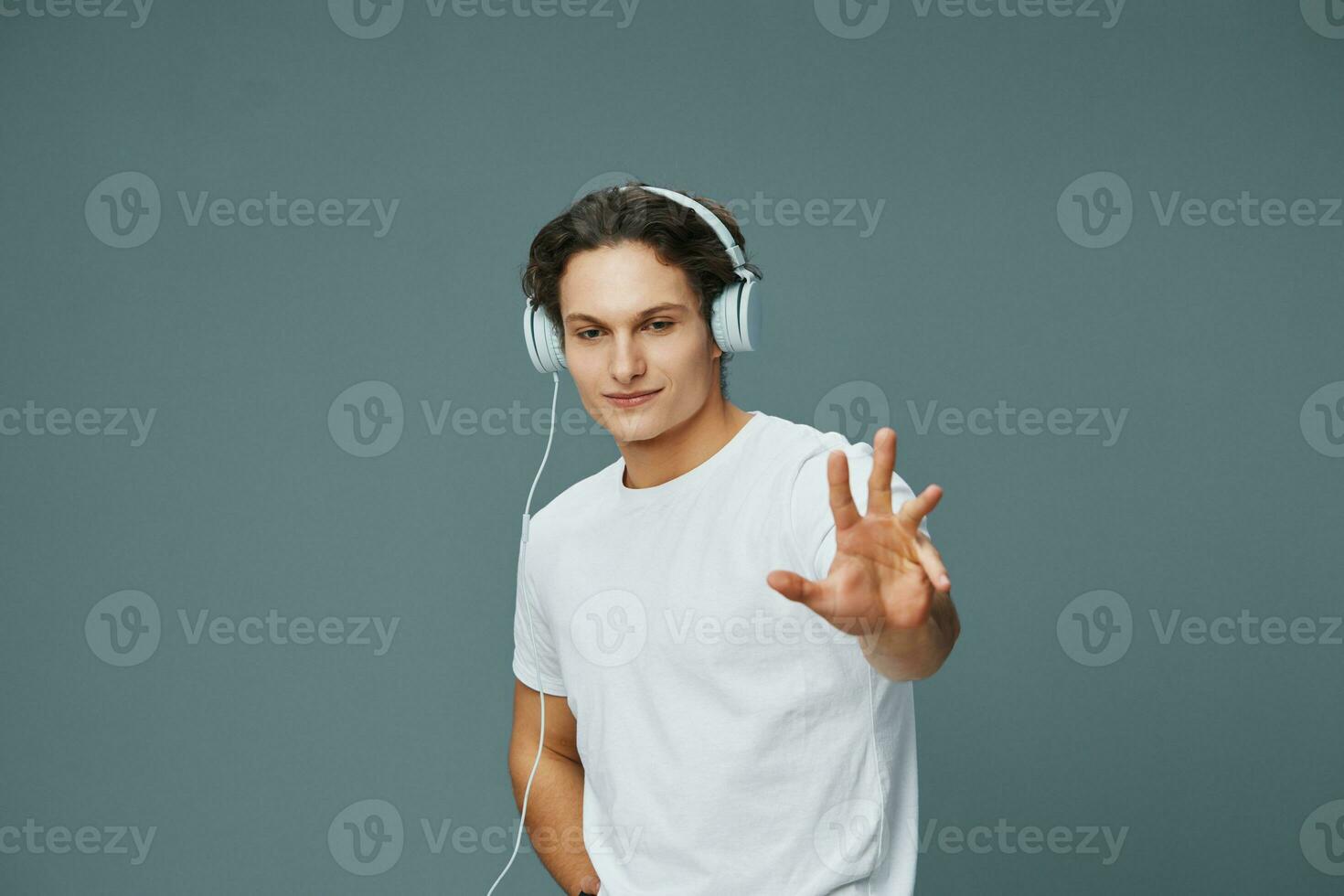hombre estudio estilo de vida entretenimiento joven música auriculares escucha retrato contento camiseta foto