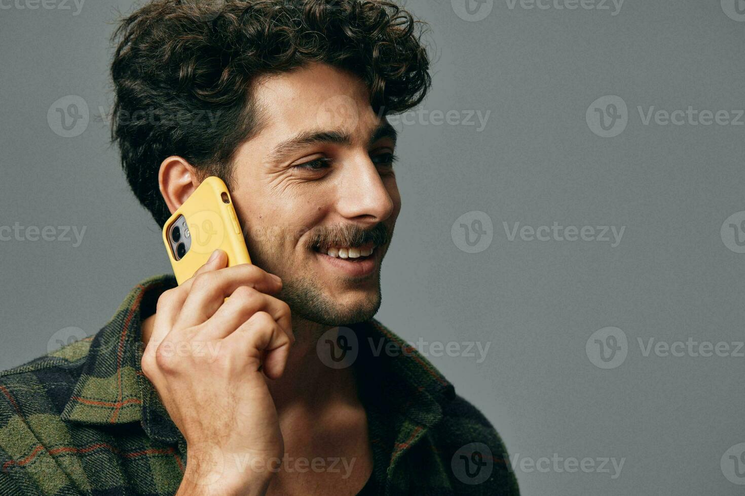 adulto hombre estudio joven elegante contento antecedentes gris confidente teléfono escucha sonrisa tecnología estilo de vida foto