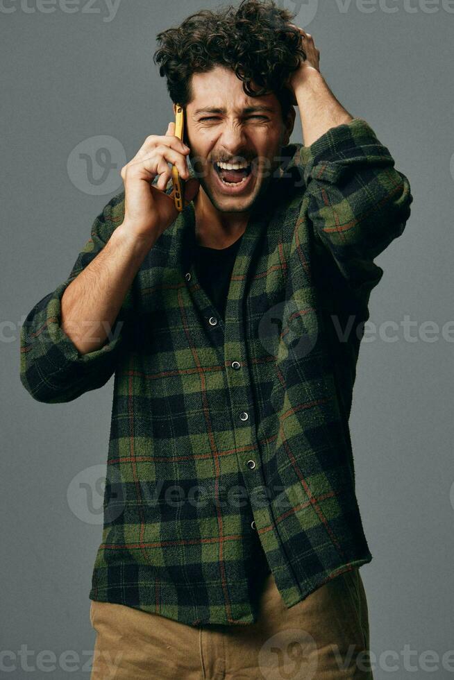 sonrisa hombre estilo de vida antecedentes gris estudio teléfono elegante contento foto