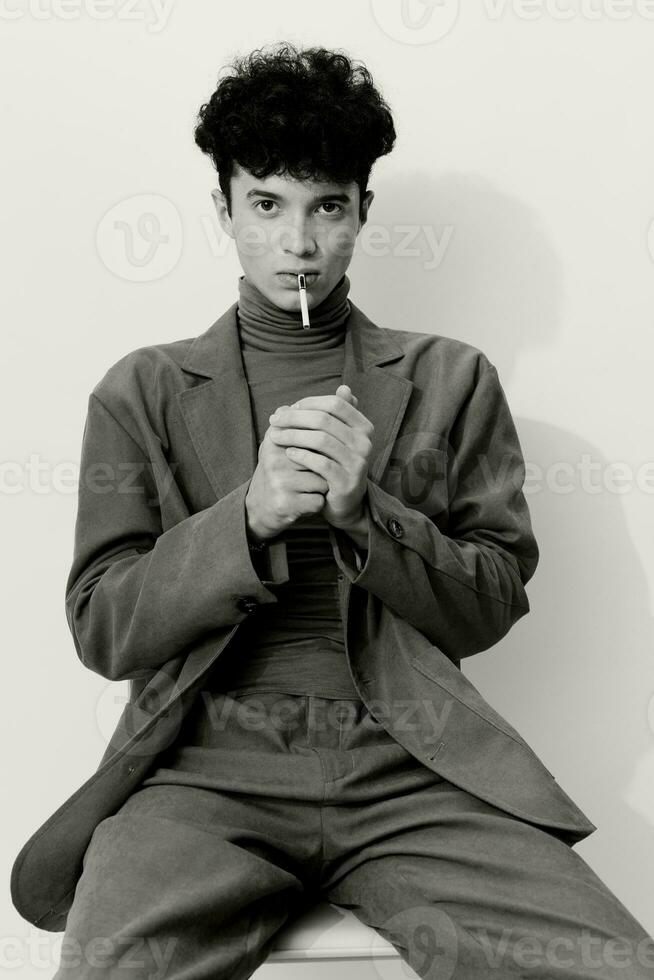 Fashion man thoughtful smoking portrait black cigarette student and handsome white hipster studio face sitting photo