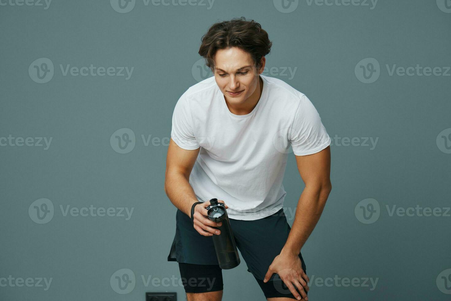 isolated man athletic guy drink bottle water fit sport t-shirt exercise background photo