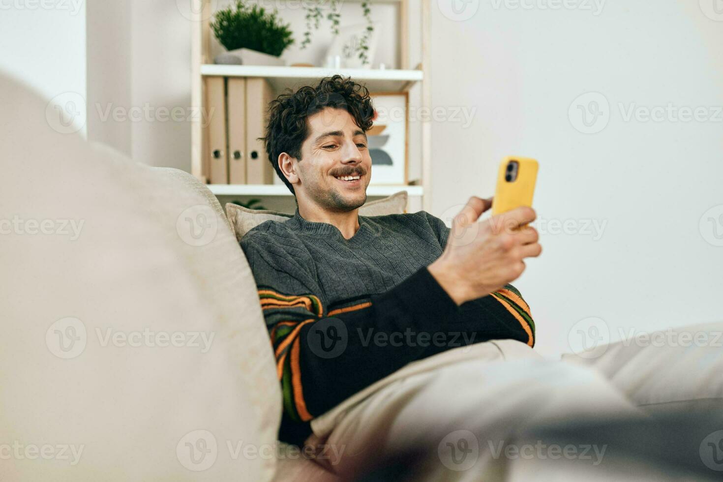 Typing man freelance looking leisure wireless sofa modern message phone communication lifestyle home technology photo