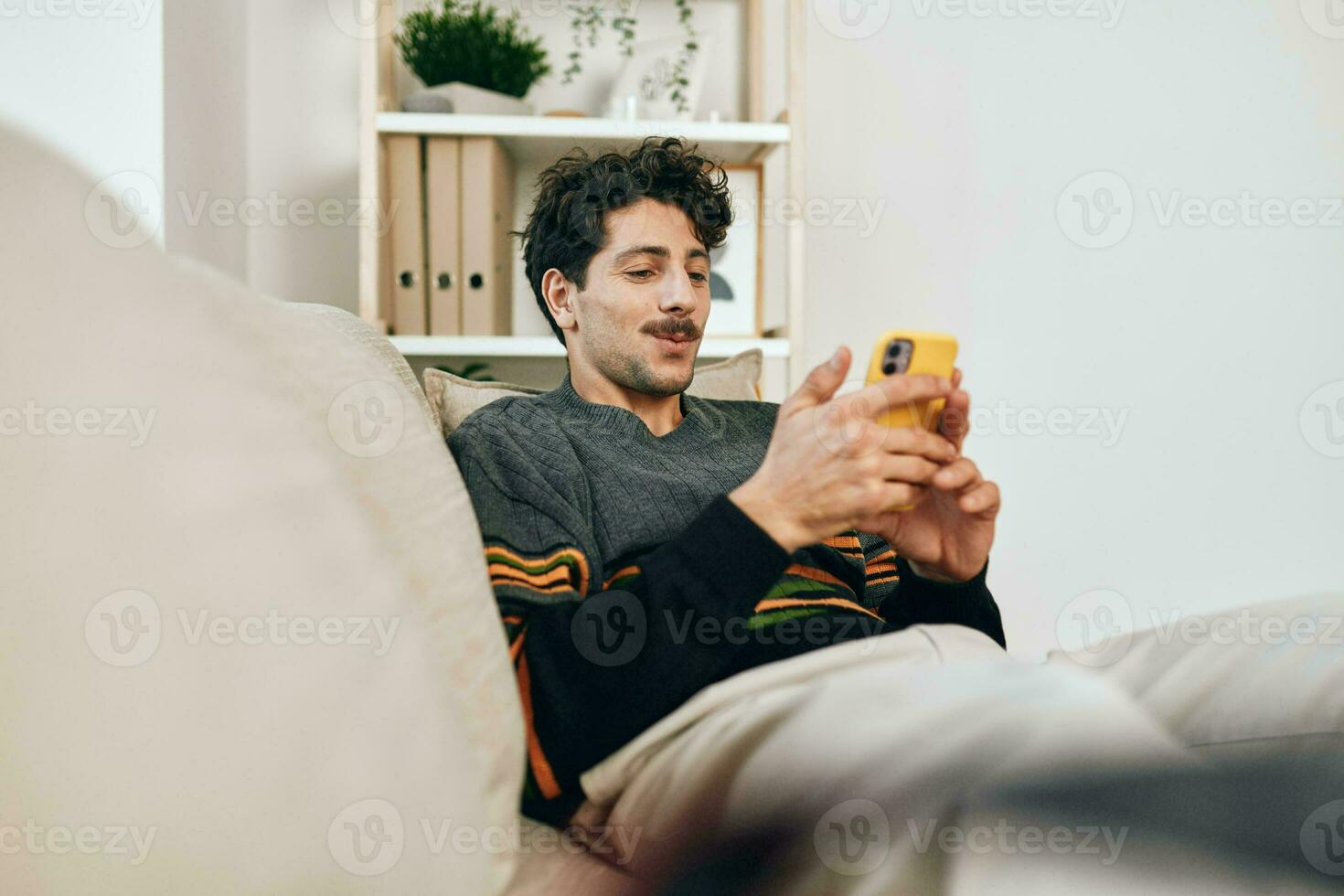 Man technology modern message businessman communication typing lifestyle sofa internet phone handsome home freelance photo
