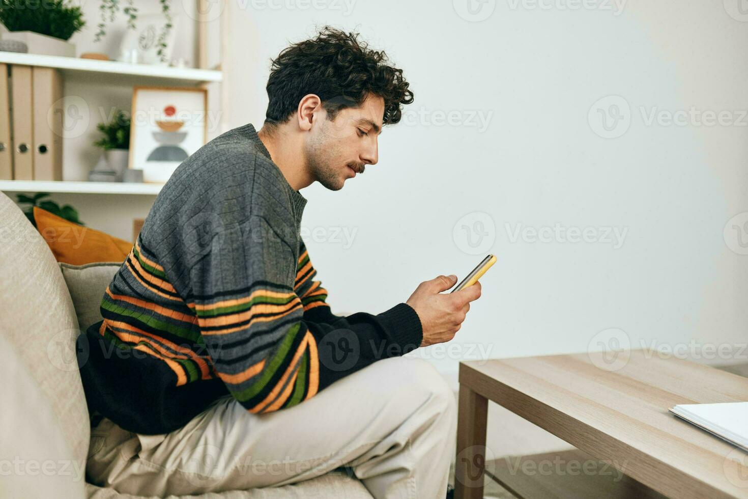 Young man message technology communication typing leisure person lifestyle sitting freelance home sofa phone photo