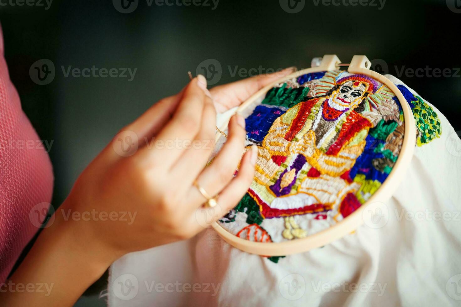 a person is holding a embroidery hoop with a picture on it photo