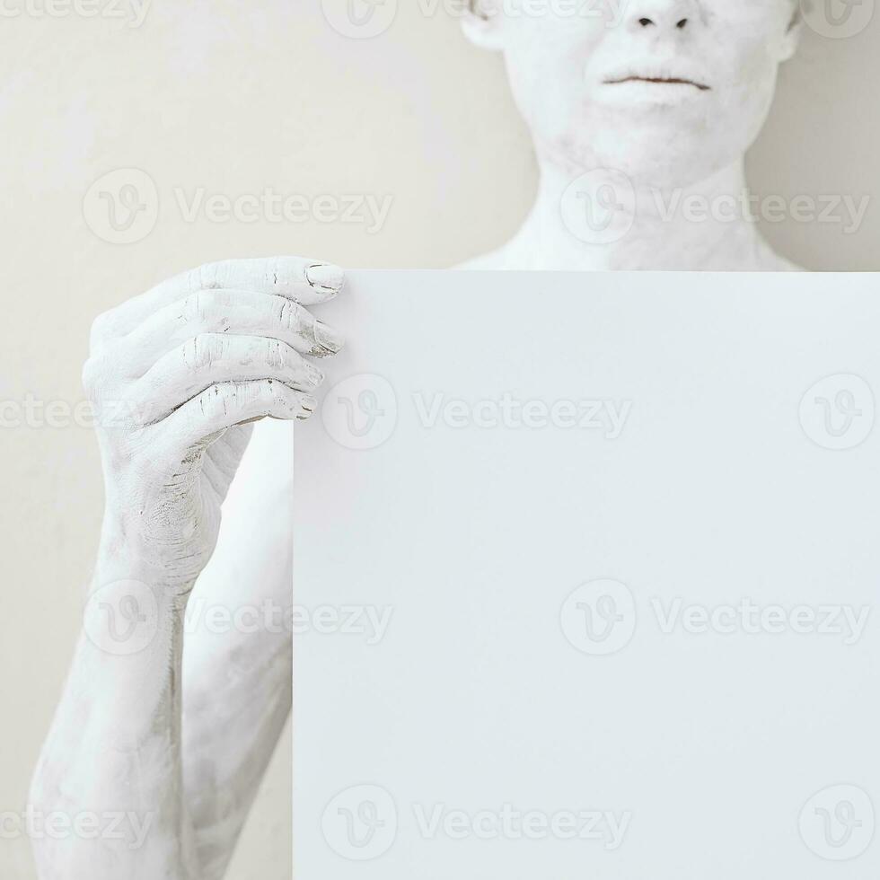 Blank design poster template. Woman covered with white paint holding  a paper. Focus on hands. photo