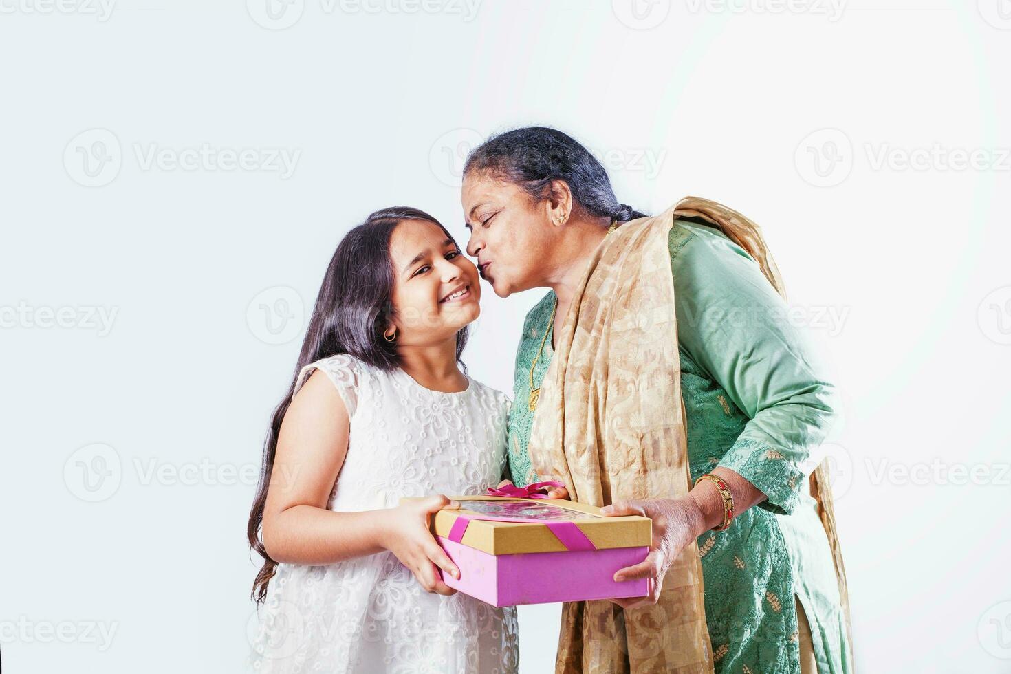 linda pequeño indio niña posando con su abuela terminado blanco antecedentes foto