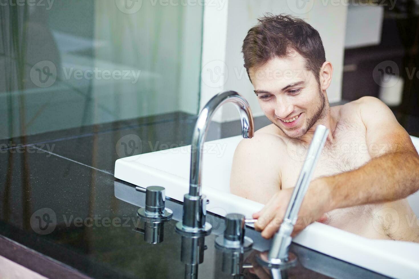Young man on the bath tube photo