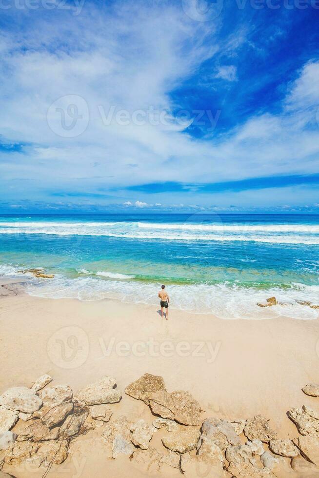tiny figure of a man looking at the ocean photo