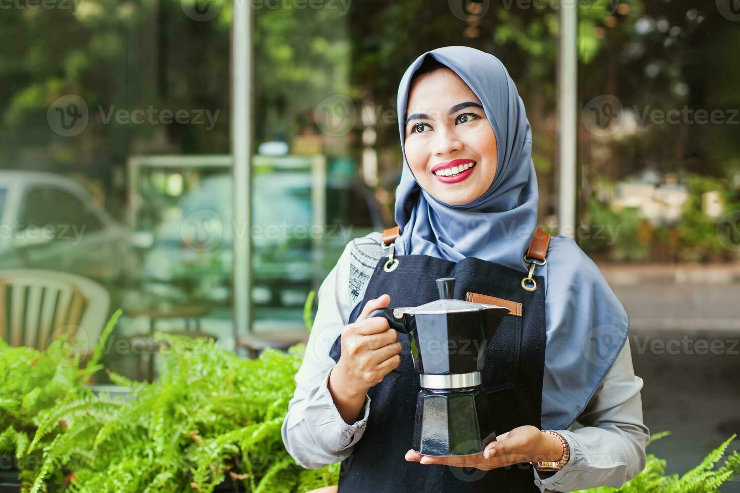 Cute Indonesian muslim waitress bringing hot coffee in a coffee shop Cute Indonesian muslim waitress bringing hot coffee in a coffee shop