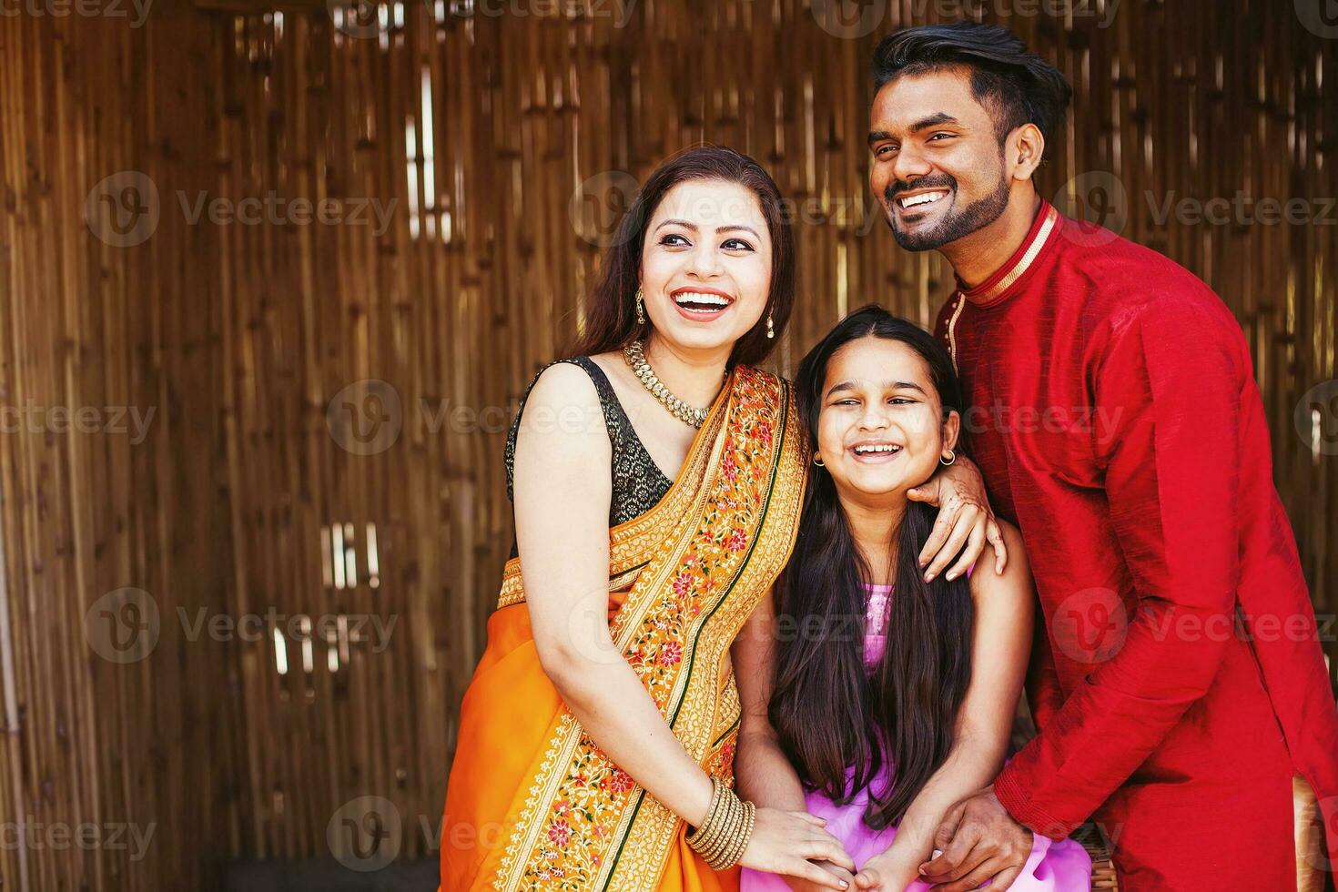 a family posing for a photo in traditional indian attire