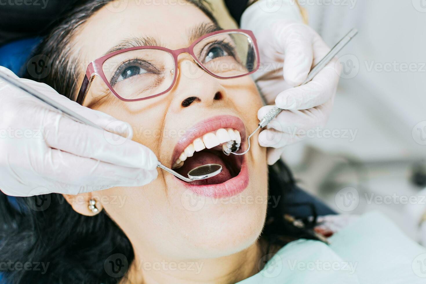 Patient checked by dentist, close up of dentist with patient, dentist performing root canal treatment on patient, dentist performing dental checkup photo