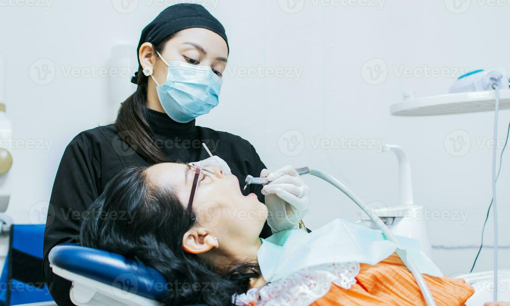 un dentista limpieza un del paciente boca, un dentista limpieza un del paciente caries, un dentista limpieza un del paciente boca, el estomatólogo limpieza un del paciente dientes foto