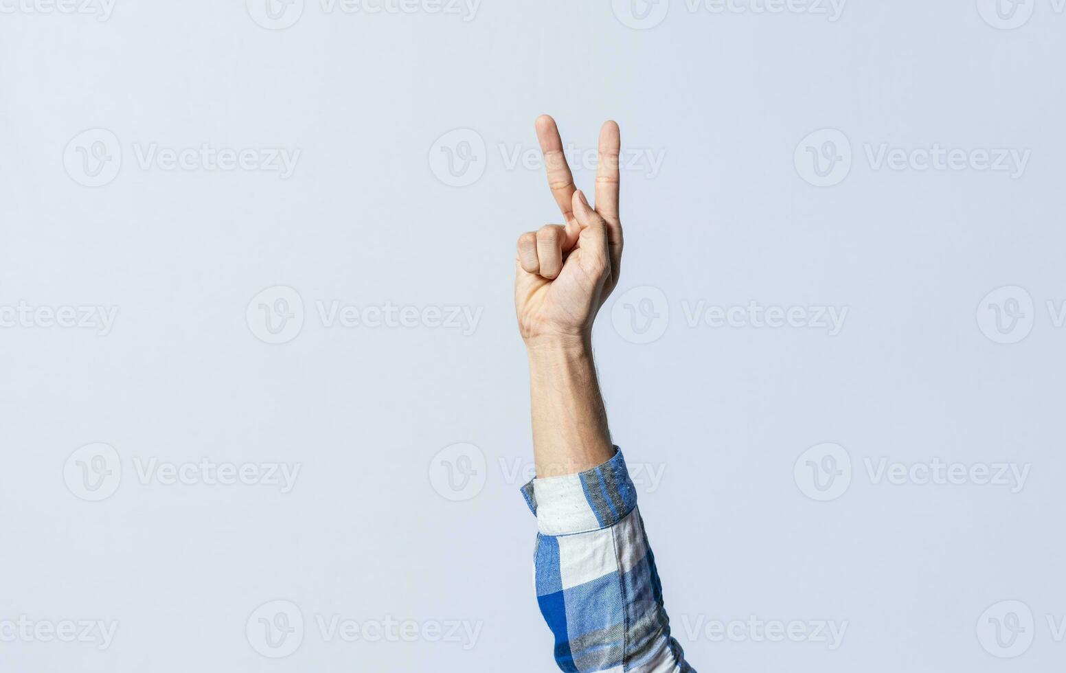 Hand gesturing the letter K in sign language on an isolated background. Man's hand gesturing the letter K of the alphabet isolated. Letters of the alphabet in sign language photo