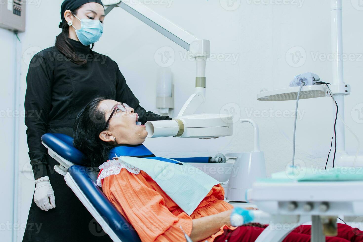 un hembra dentista ejecutando dental rayos X, hembra dentista ejecutando rayos X en un paciente, hembra dentista ejecutando dental rayos X foto