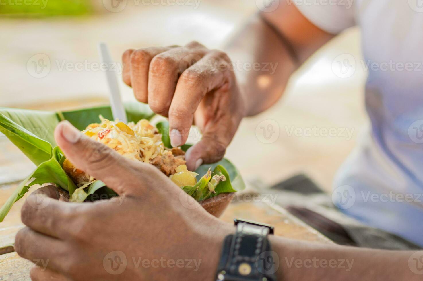 de cerca de un persona comiendo vigorón, persona comiendo vigorón en un de madera mesa foto