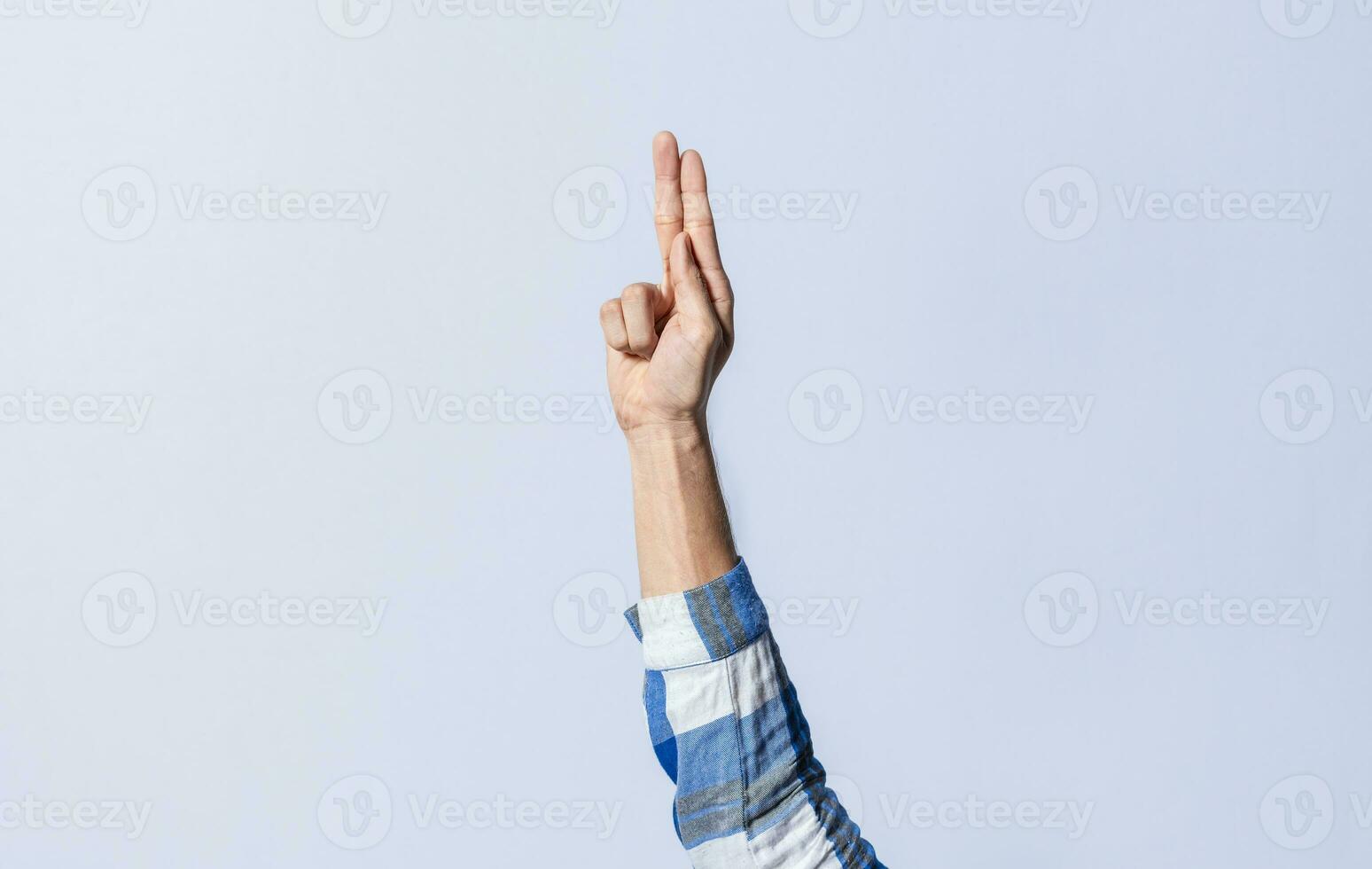 Hand gesturing the letter U in sign language on an isolated background. Man's hand gesturing the letter U of the alphabet isolated. Letter U of the alphabet in sign language photo