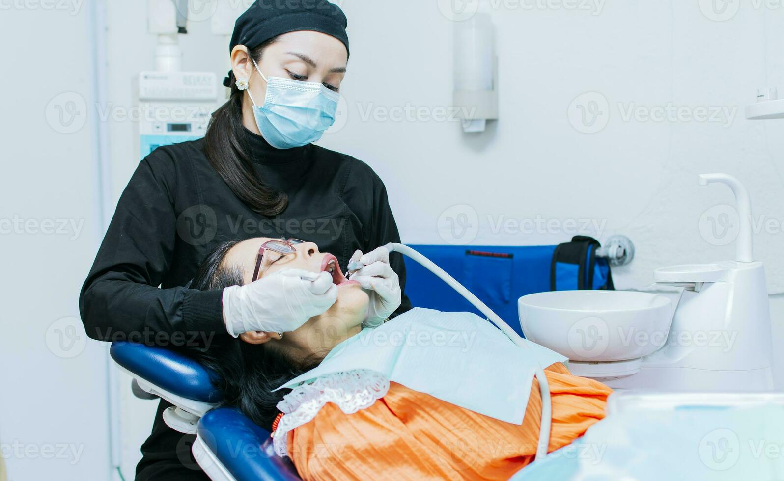 el estomatólogo limpieza un del paciente dientes, un dentista limpieza un del paciente boca, un dentista limpieza un del paciente caries, un dentista limpieza un del paciente boca foto