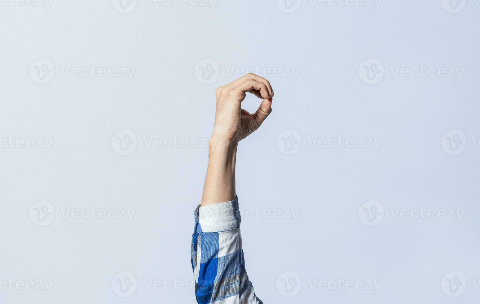 Hand gesturing the letter O in sign language on an isolated background. Man's hand gesturing the letter O of the alphabet isolated. Letter O of the alphabet in sign language photo