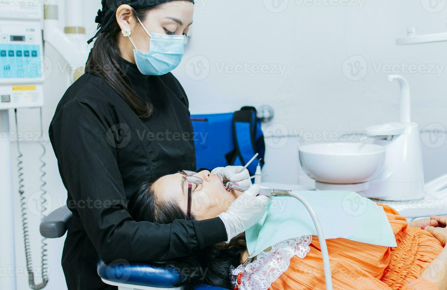 The stomatologist cleaning a patient's teeth, a dentist cleaning a patient's mouth, a dentist cleaning a patient's caries, a dentist cleaning a patient's mouth photo
