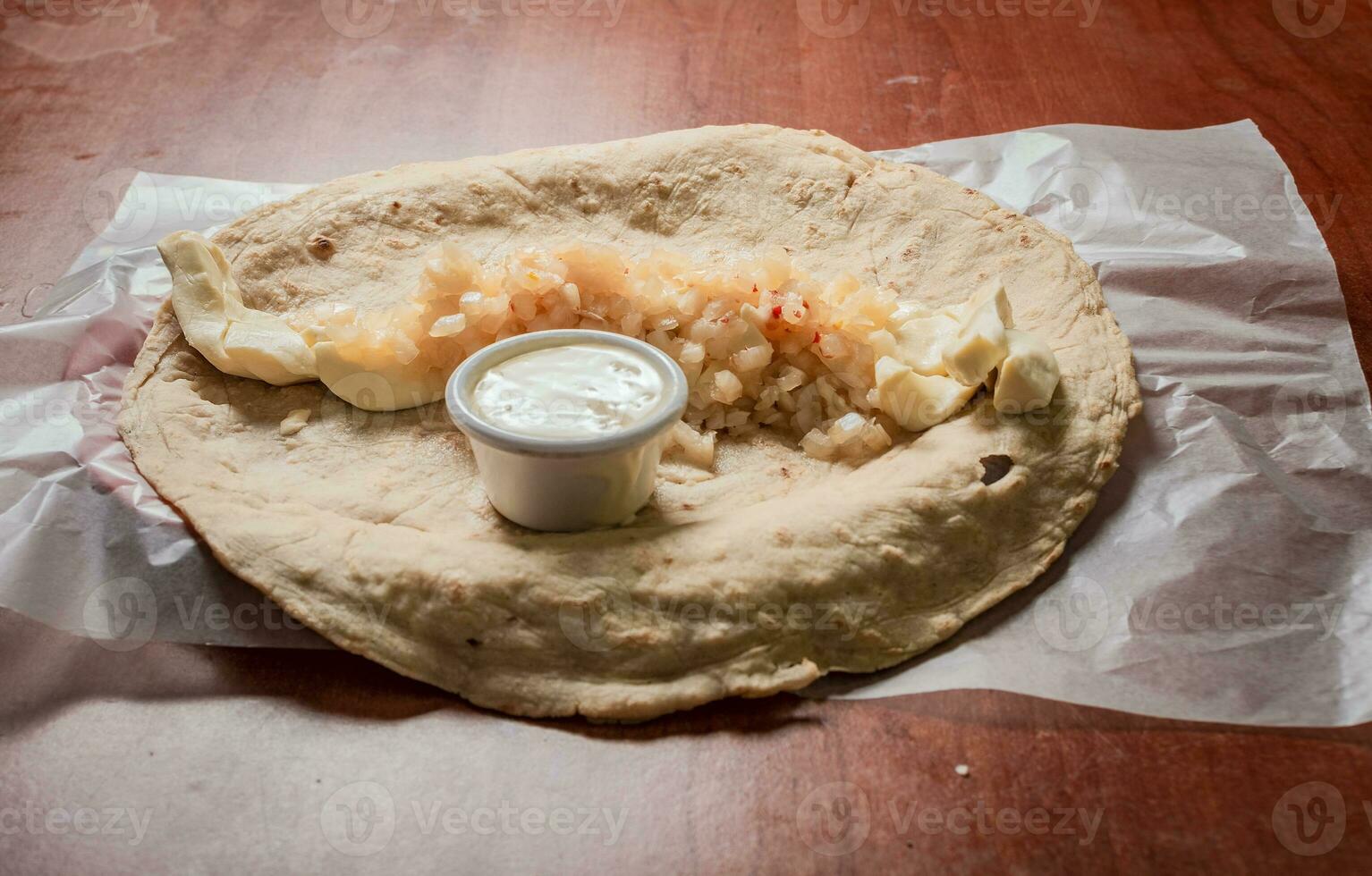 Top view of Nicaraguan Quesillo served on wooden table. Traditional Nicaraguan Quesillo served on wooden table, Close up of Nicaraguan Quesillo served on wooden table photo