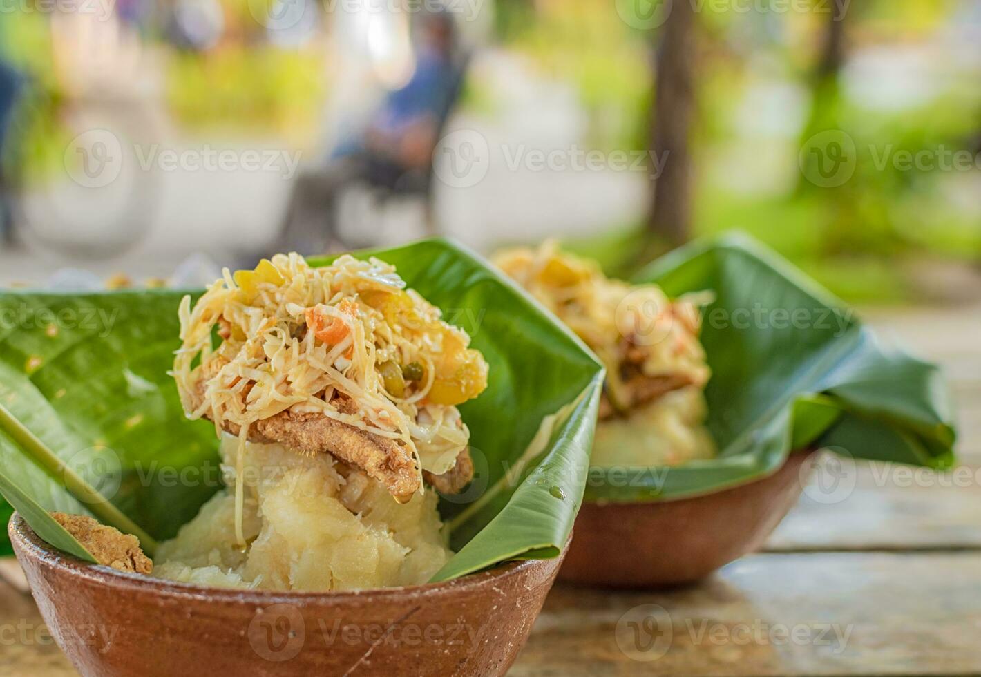 Vigoron with leaves served on a wooden table, two vigorones served on wooden background, vigoron typical food from nicaragua photo